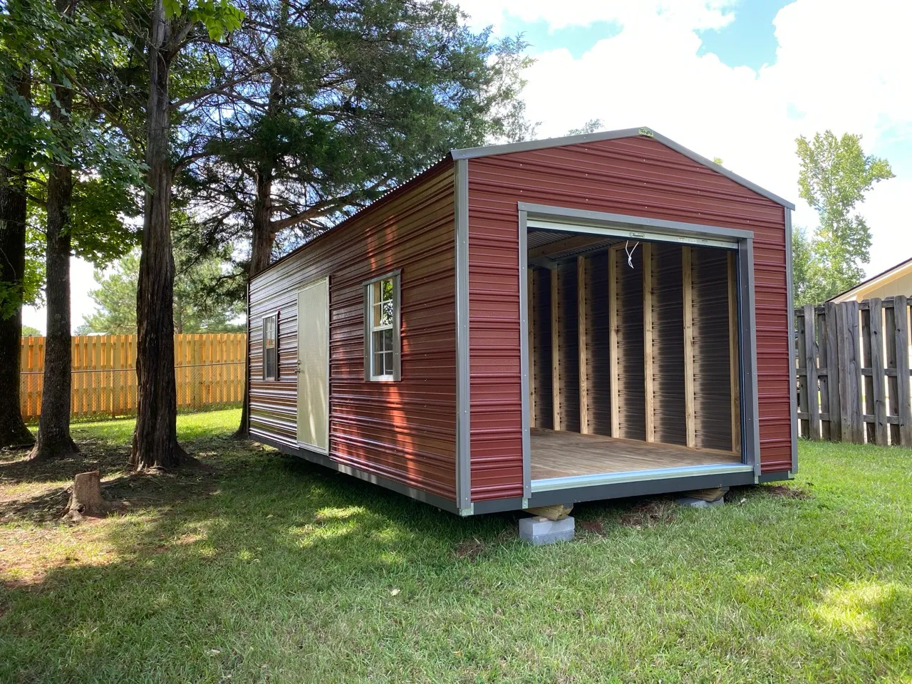 Barn loft maroon aluminum shed with roll-up door open