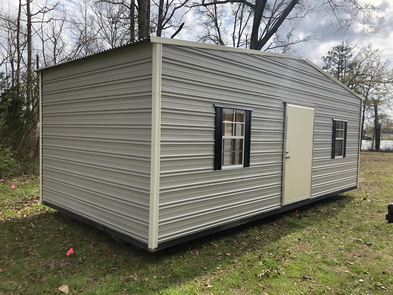 Gray aluminum shed with black shutters