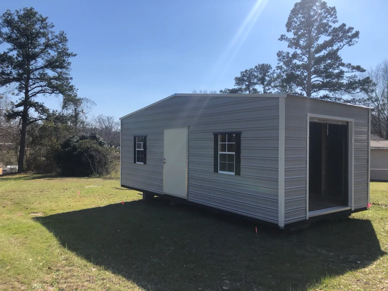 Gray aluminum shed with roll-up door open
