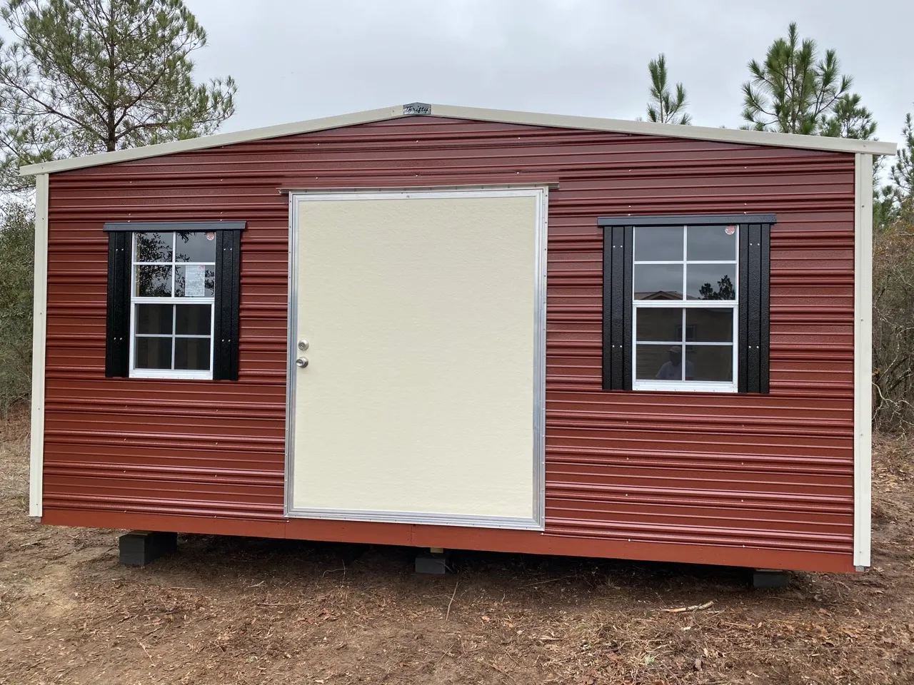 Maroon aluminum shed with black shutters